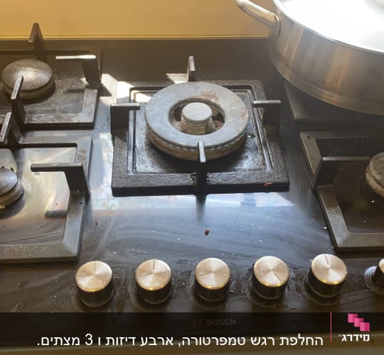 כיריים גז עם סירים וכפתורי שליטה